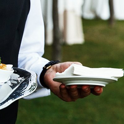 Waiter carries plate with tasty snacks 
