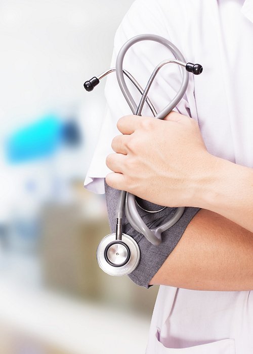 Doctor with a stethoscope in the hands and hospital background