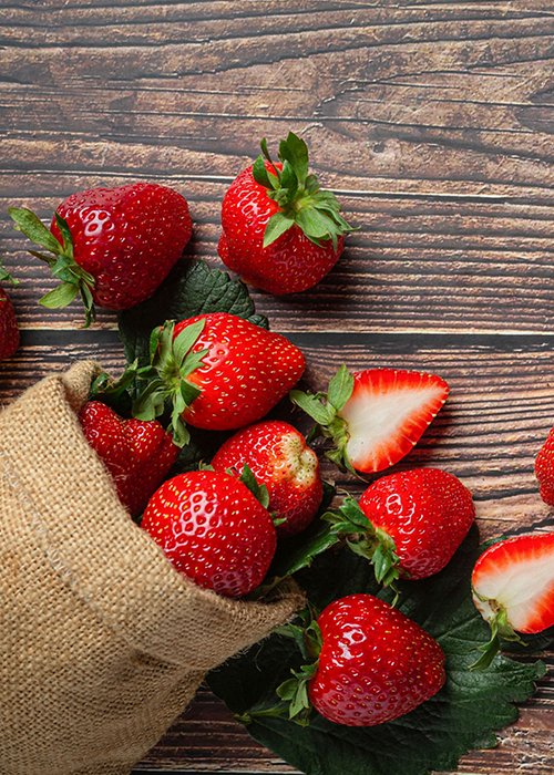 Fresh strawberries in a bowl on wooden table