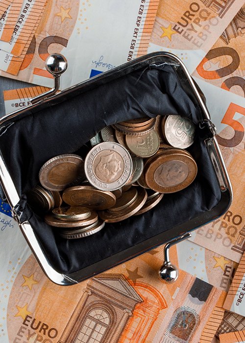 Financial concept with coins in purse on banknote and plaster background flat lay. 