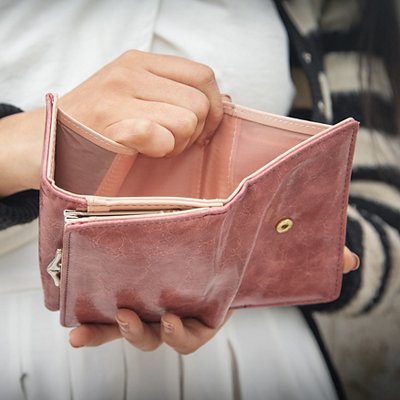 Young woman holding empty wallet. No Money