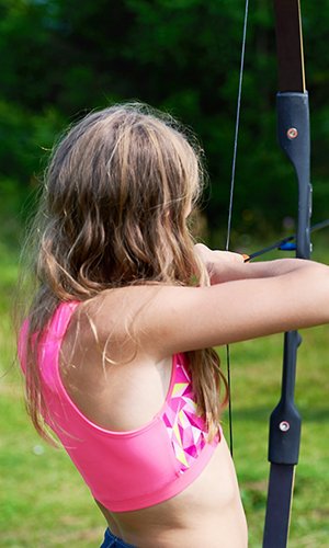 Girl teenager with bow nock and aims to target
