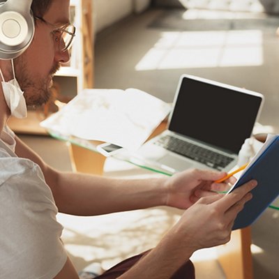 Young man studying at home during online courses for laborer, journalist, developer. Young man studying at home during online courses for laborer, journalist, developer.