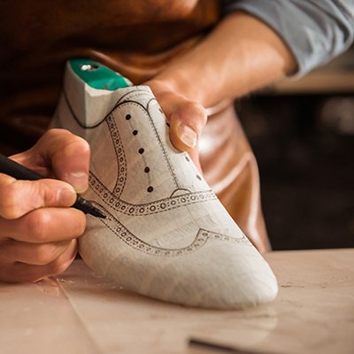 Close up of a male shoemaker drawing design Close up of a male shoemaker drawing design