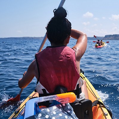 Faceless woman rowing kayak on sea Faceless woman rowing kayak on sea