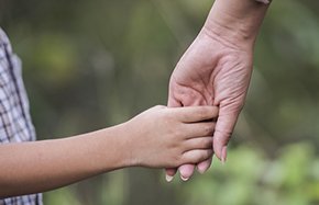 Close up of happy mum and son holding hand in a park. Family concept. Close up of happy mum and son holding hand in a park. Family concept.