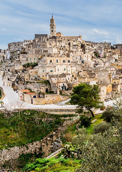 Long panoramic views of the rocky old town of Matera with its stone roofs.