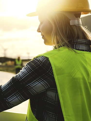 Young engineer working for alternative energy with wind turbine and solar panel - Innovation and green power concept 