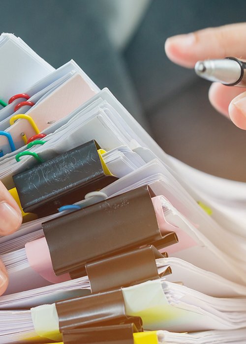 Accounting planning budget concept : Business woman offices working for arranging documents unfinished stack of document papers with pen, calculator, clip papers on busy office desk