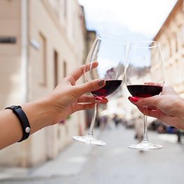 hands close up of couple toasting glasses of wine, traveling in europe, summer vacation, drinking alcohol, point of view