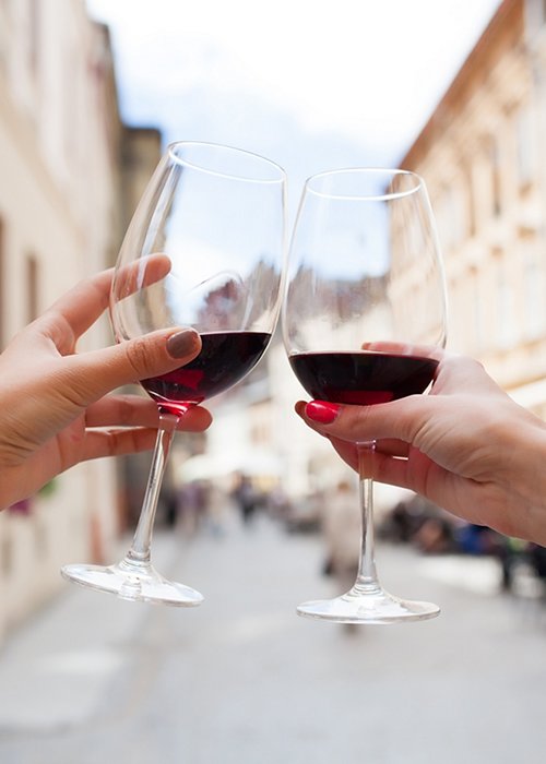 hands close up of couple toasting glasses of wine, traveling in europe, summer vacation, drinking alcohol, point of view