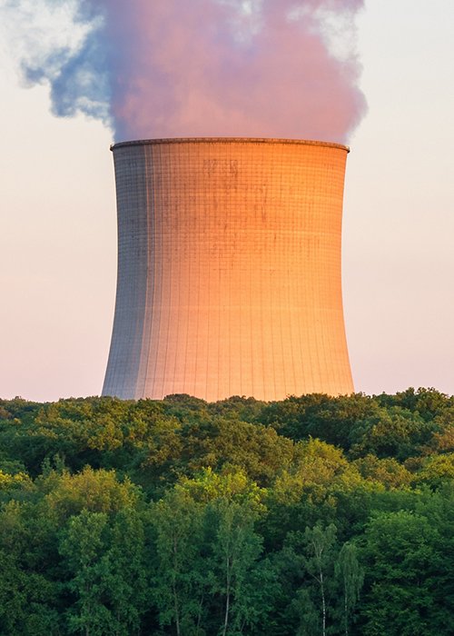Steaming Cooling Towers at Nuclear Power Plant around Sunset