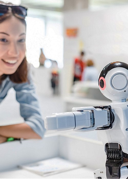 A female student controls the work of an intelligent humanoid robot