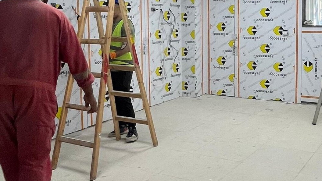 Workers at work in a room with some ladders
