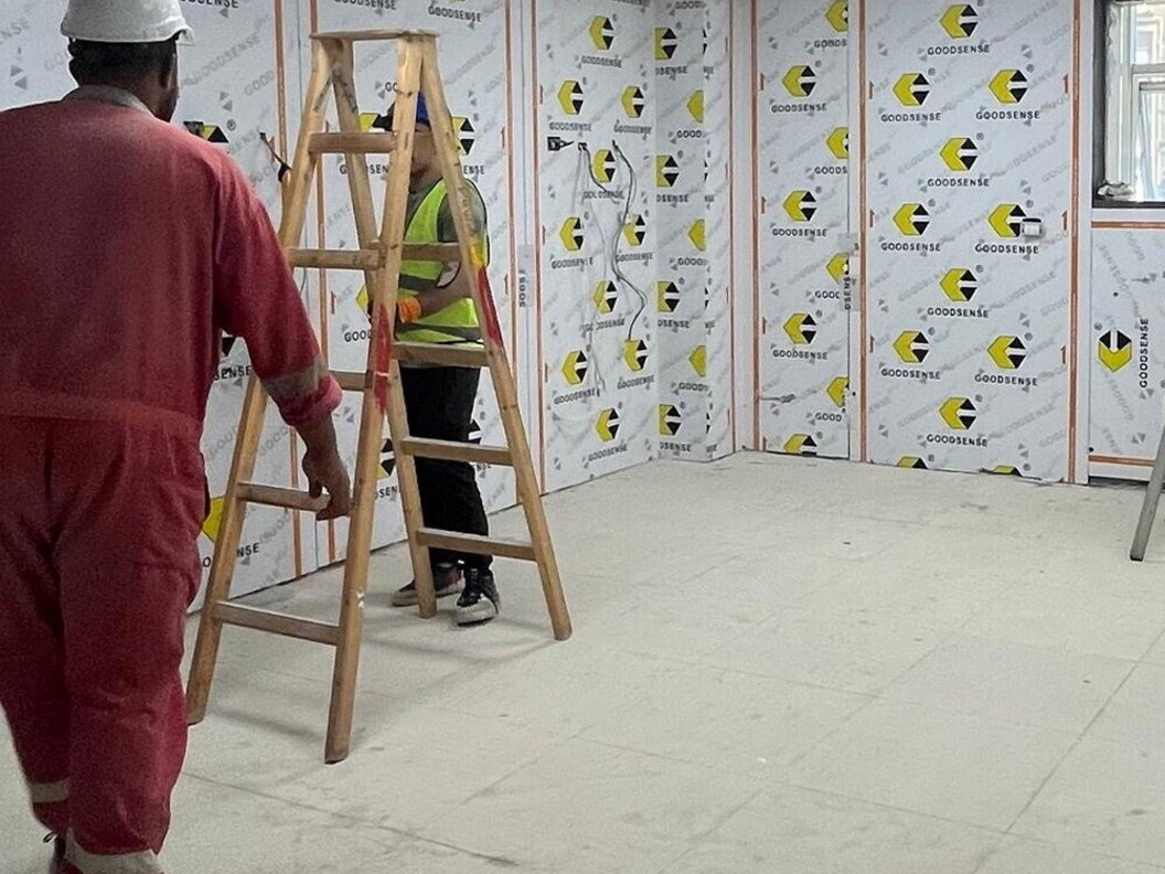 Workers at work in a room with some ladders