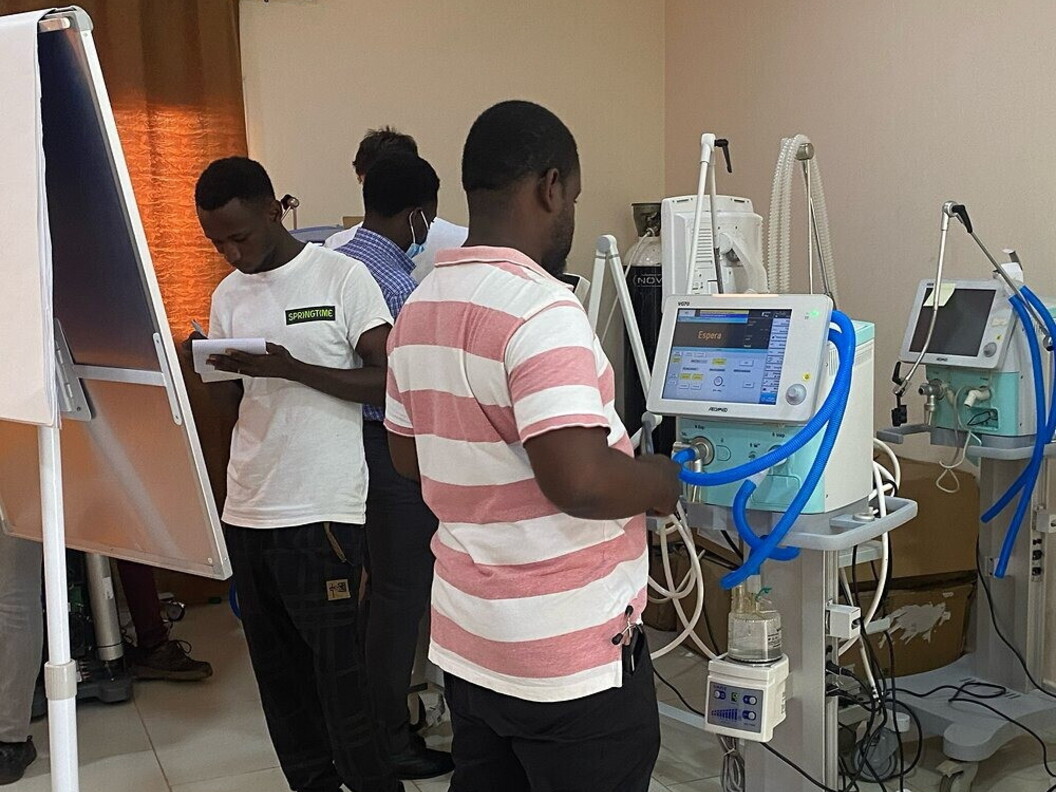 Un gruppo di persone sono concentrate sul funzionamento di un monitor