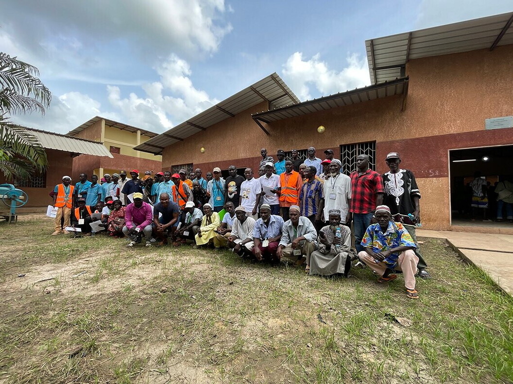 A group of people pose for a photo outside a building