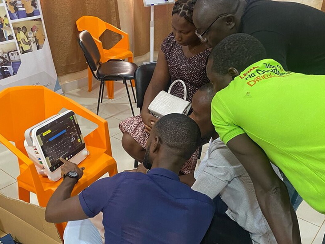 Un gruppo di persone sono concentrate sul funzionamento di un monitor