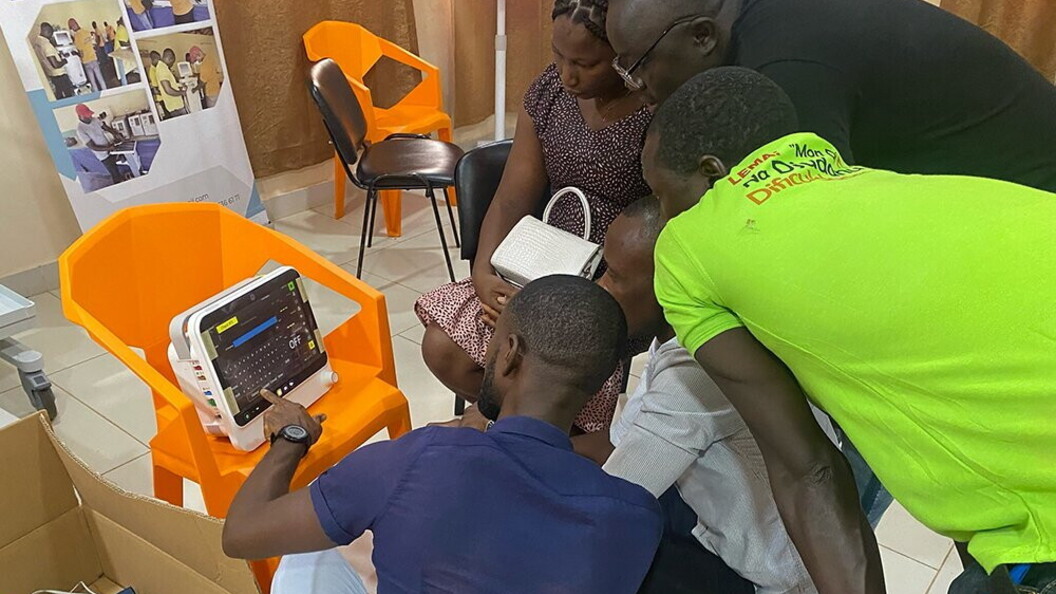 Un gruppo di persone sono concentrate sul funzionamento di un monitor