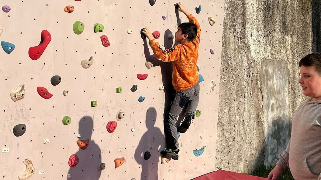 Un ragazzo si allena su una parete da arrampicata