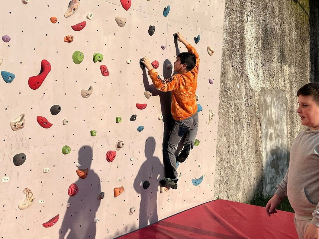 Un ragazzo si allena su una parete da arrampicata