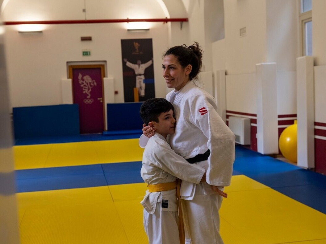 Un giovane allievo pratica arti marziali con il supporto dell’istruttrice