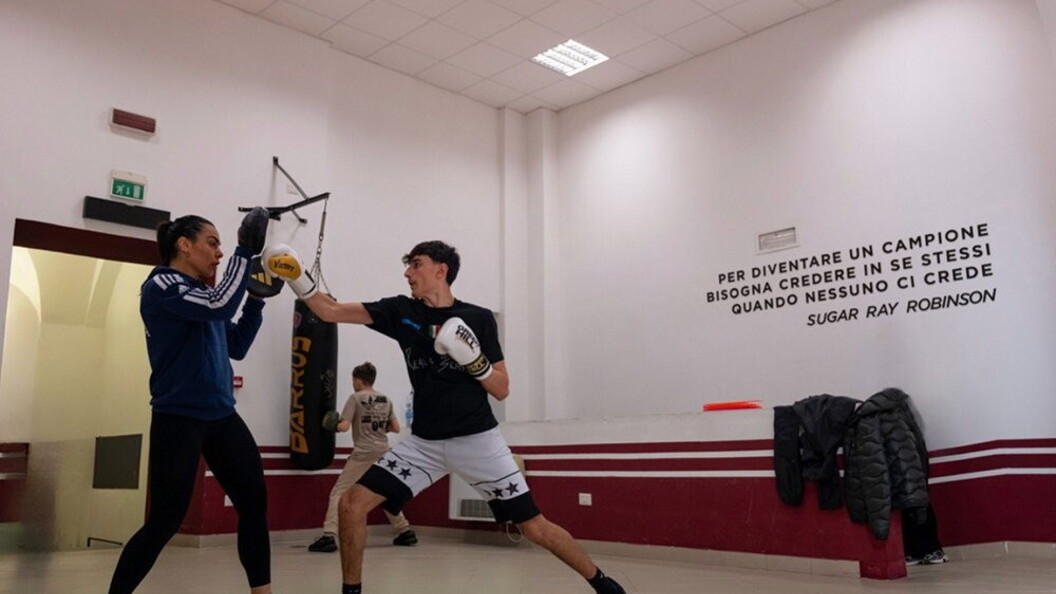 Un ragazzo si esercita con una coach in una sessione di pugilato