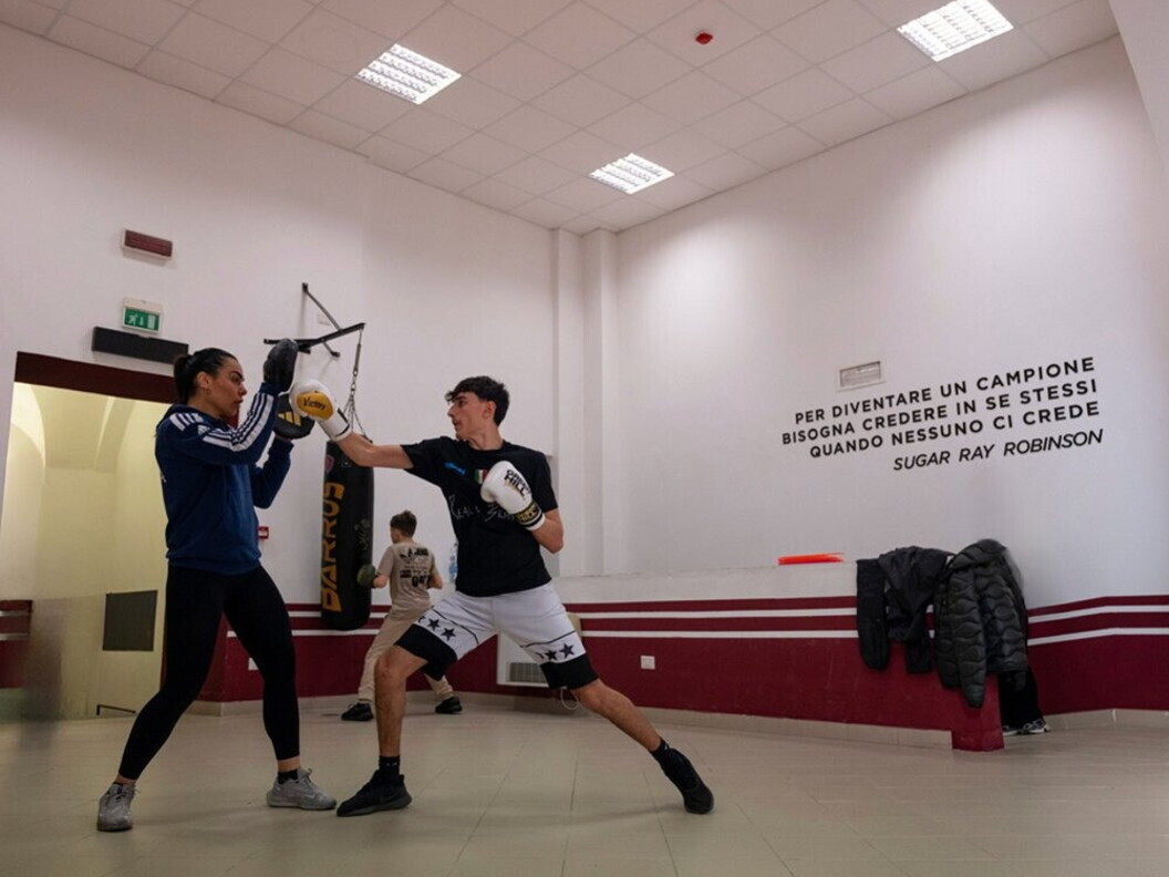 Un ragazzo si esercita con una coach in una sessione di pugilato