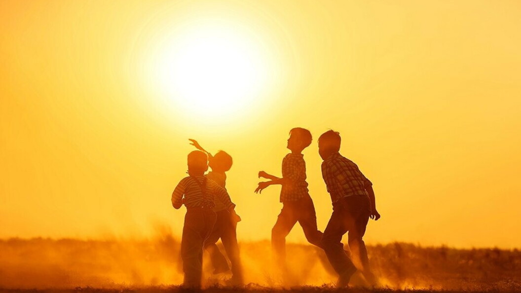 Alcuni ragazzi giocano a calcio al tramonto