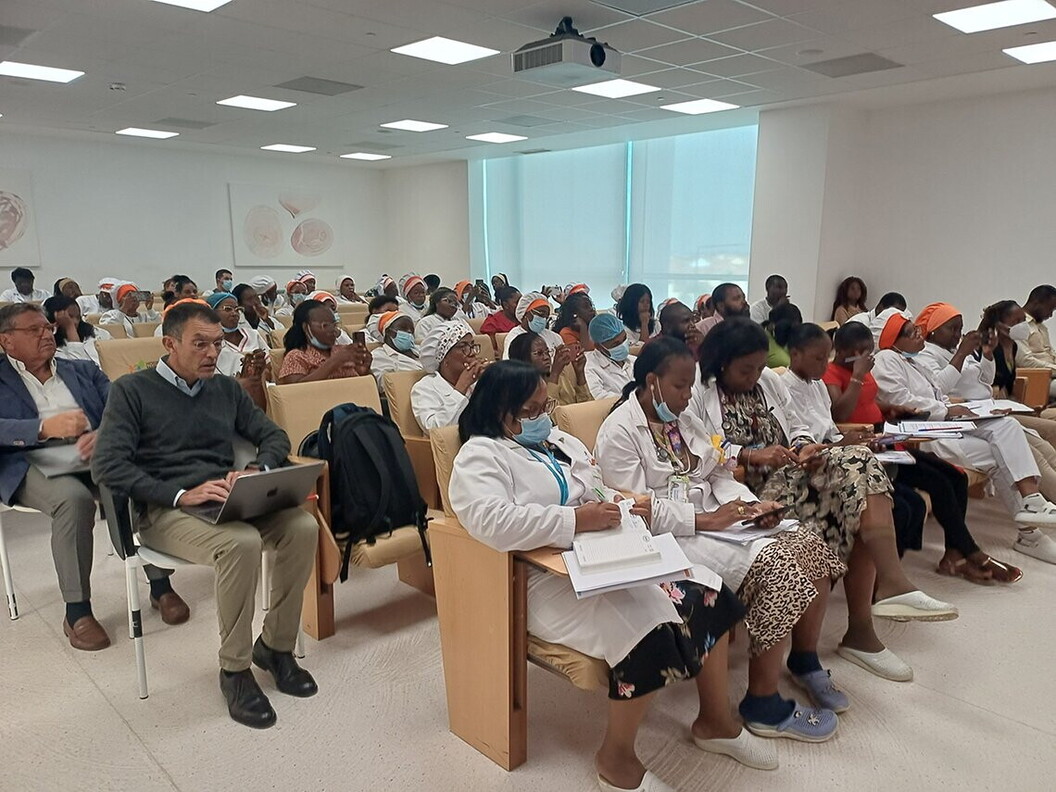 Un gruppo di uomini e donne sono sedute in un'aula e seguono una riunione
