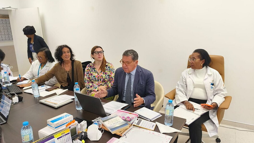 Un gruppo di uomini e donne sono sedute attorno a un tavolo da riunione