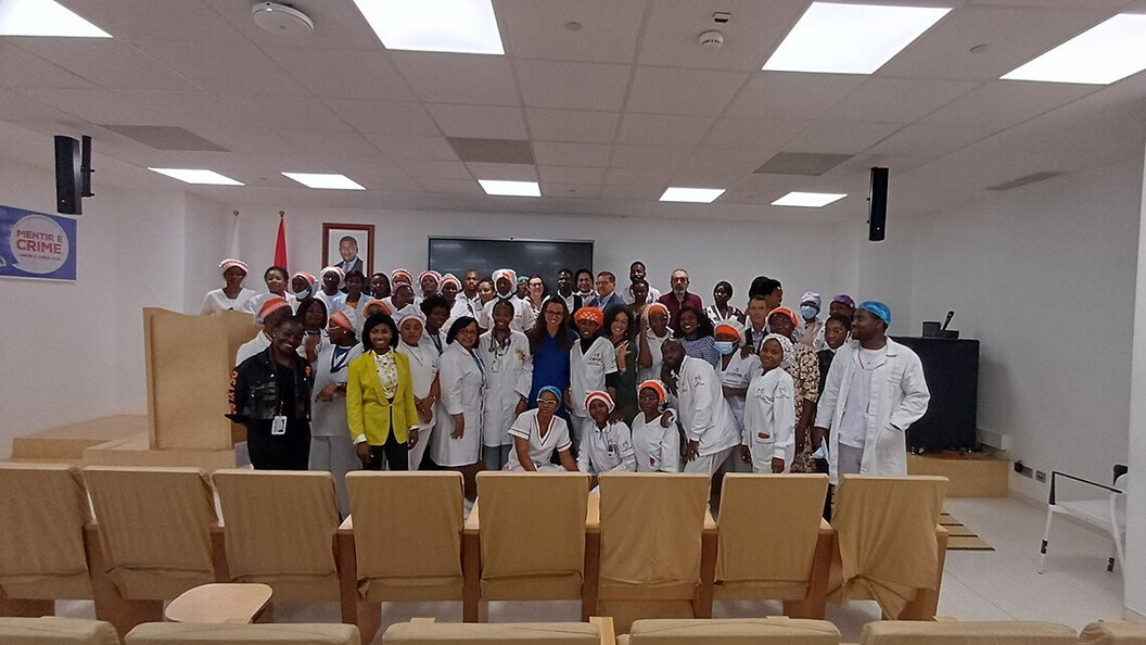 A group of people pose for a photo standing in a classroom.