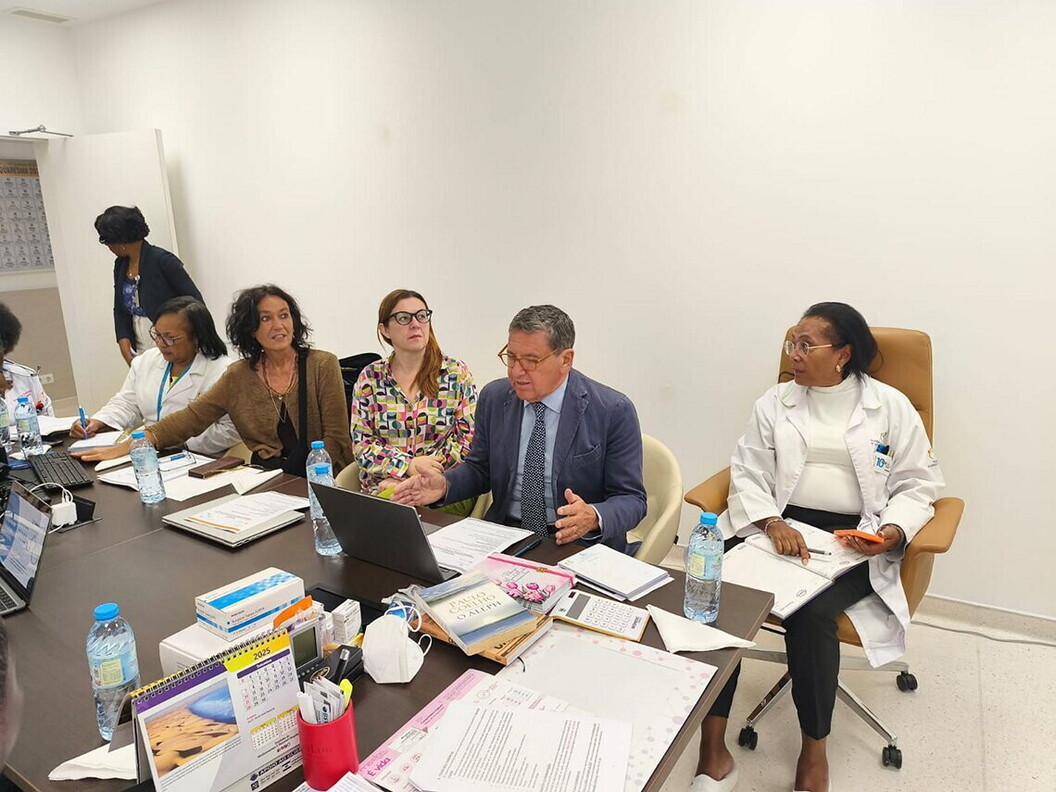 A group of men and women are seated around a conference table