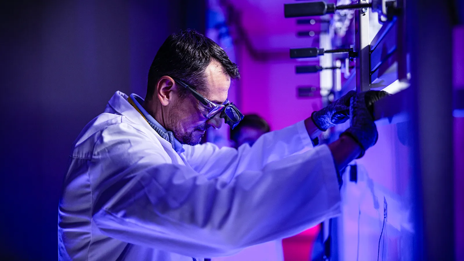 Scientist in a white coat inside a research laboratory.